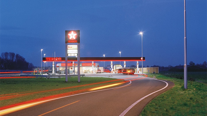 A Texaco gas station off of the highway, attractively illuminated at dusk - eye catching outdoor lighting