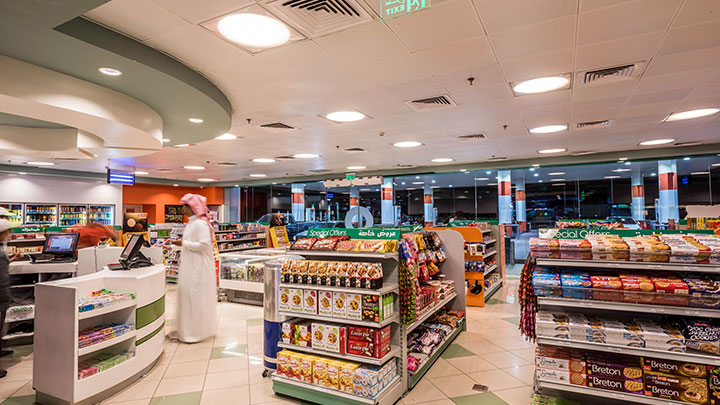 A happy convenience store customer smiles in an aisle. 