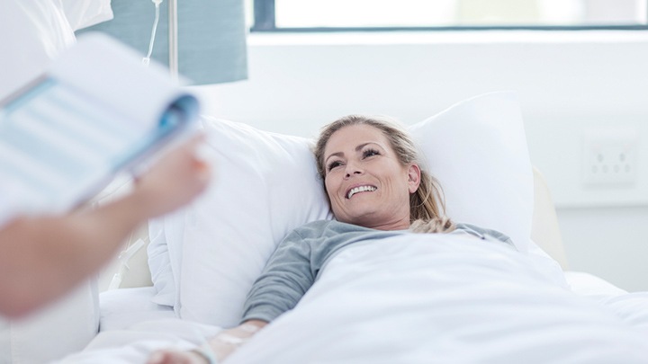 Doctors taking care of a patient in a room lighting up with Philips Healwell lighting system